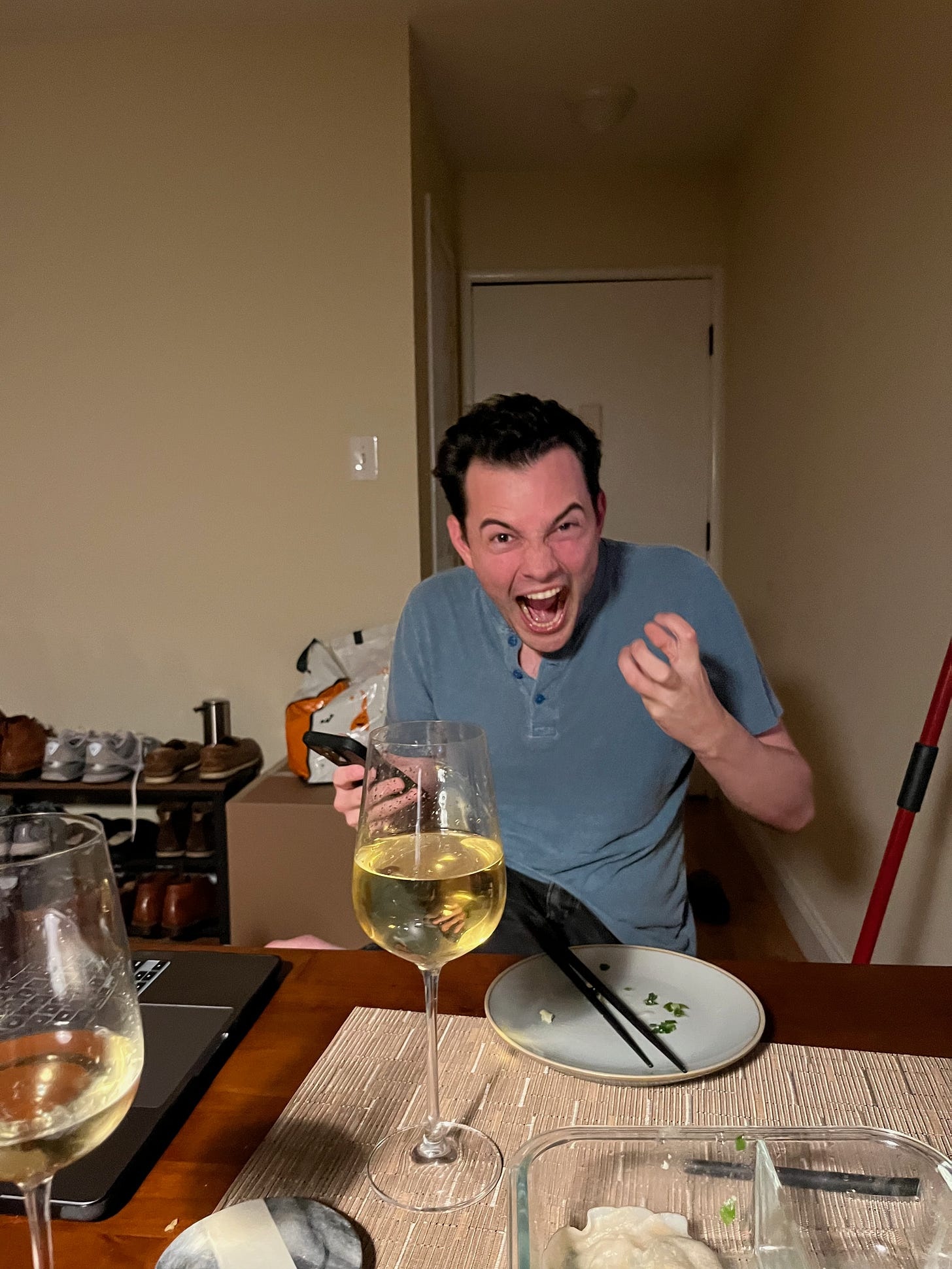 Michael Lingelbach reacting excitedly at a dining table, phone in hand