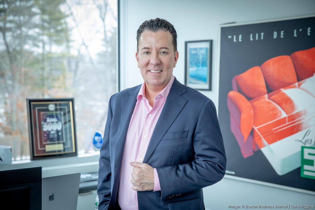 Michael London standing in an office beside a window and framed artwork