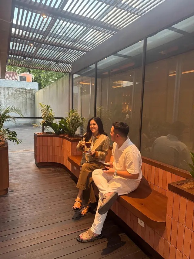 Vanessa Rae and Marvy Jonathan seated together with cups of coffee