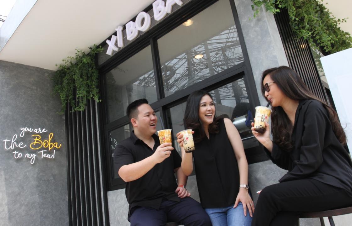 Michael Marvy Jonathan at left with two women holding drinks outside Xi Bo Ba in Menteng