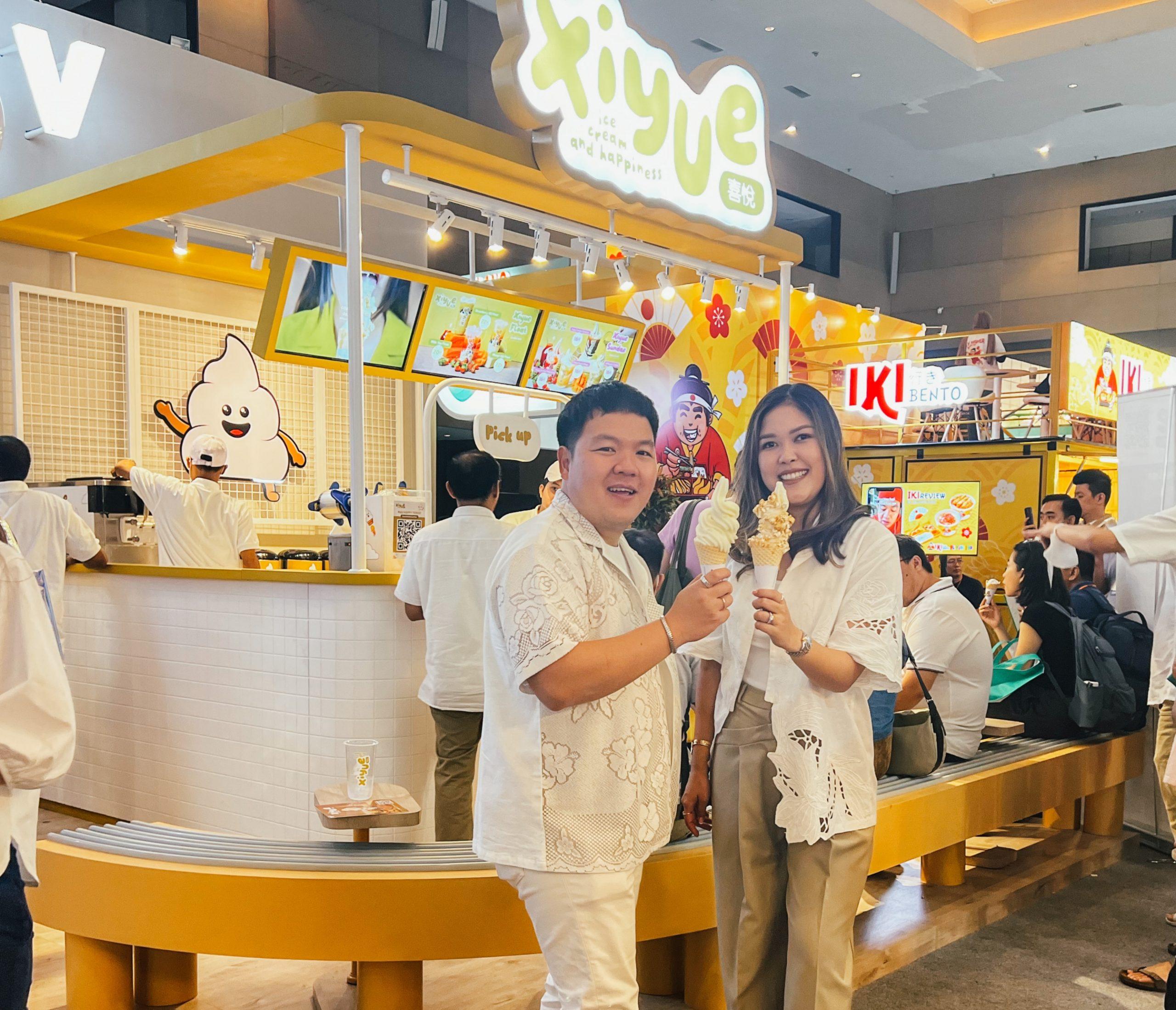 Marvy Jonathan and Vanessa Rae Putri holding ice cream cones at a yellow Xiyue outlet