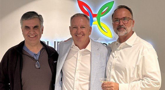 Michael McCrary, center, with two guests at PureSpectrum’s new office celebration.
