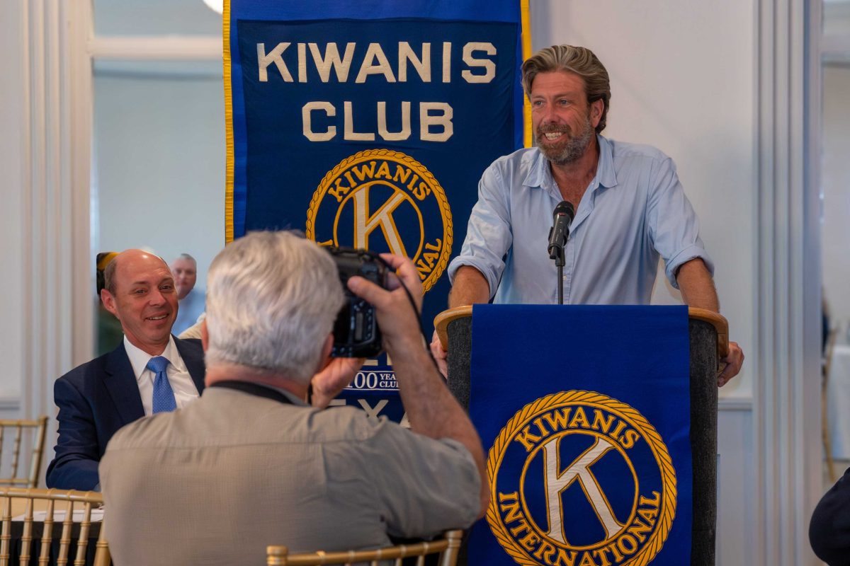 Michael McNamara answers questions at a Kiwanis Club meeting in Abilene while a reporter photographs him