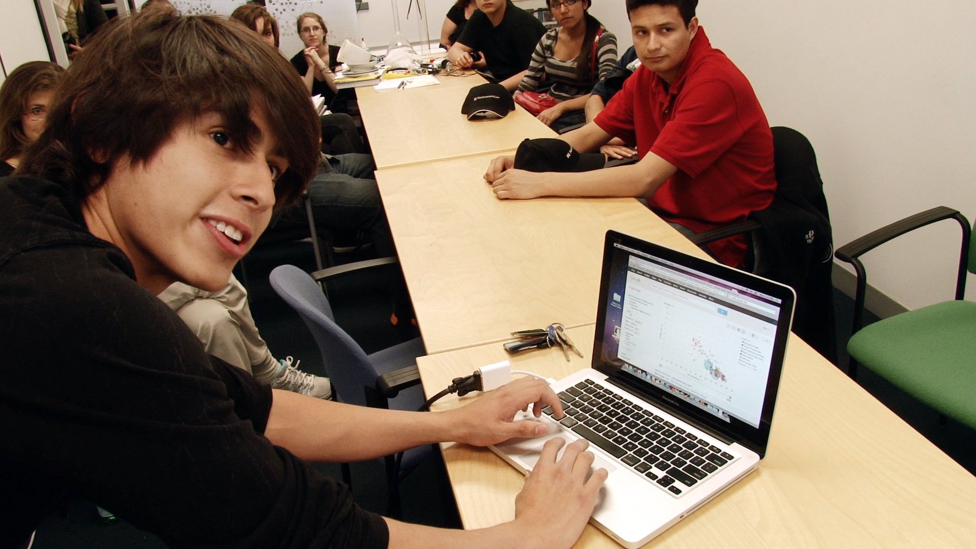 Michael Narea showing a Cleanup DePue website prototype to high school students gathered around a table