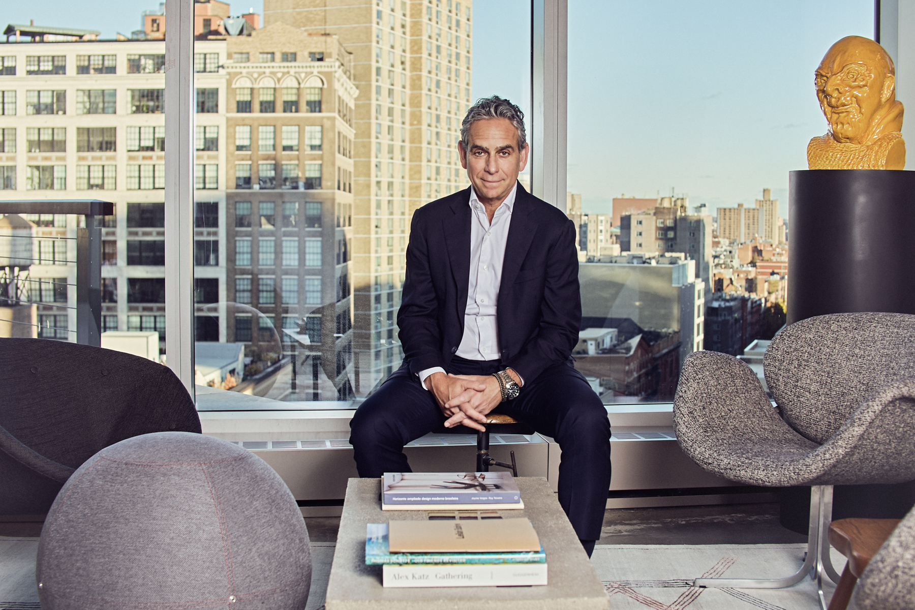 Michael Nierenberg seated among modern chairs at Rithm Capital’s New York offices