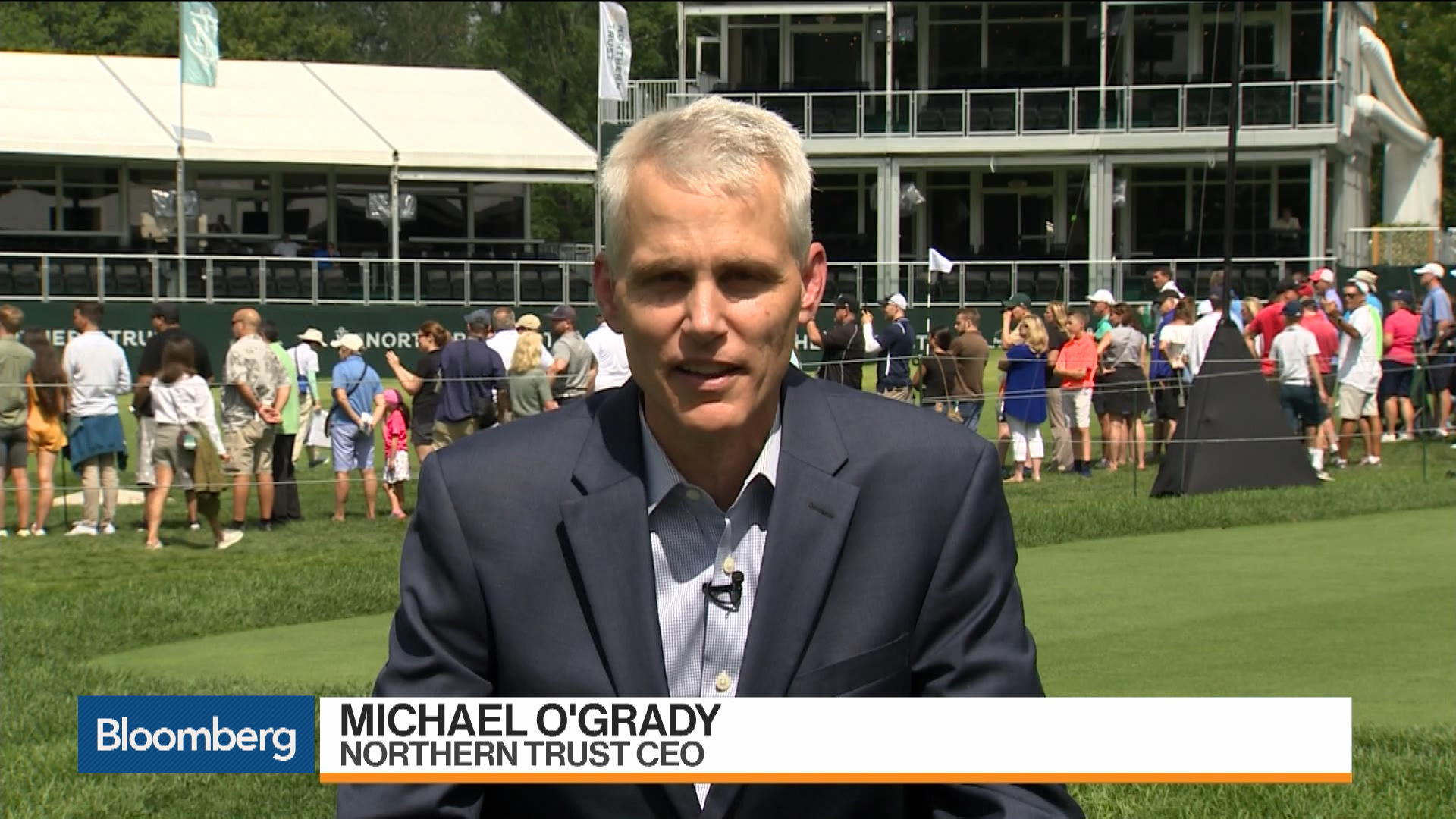 Michael O’Grady speaking outdoors during a Bloomberg television interview at a golf event