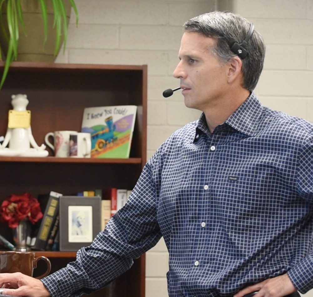 Michael Paul at work wearing a headset, pictured in the University of Utah’s 2015 annual report