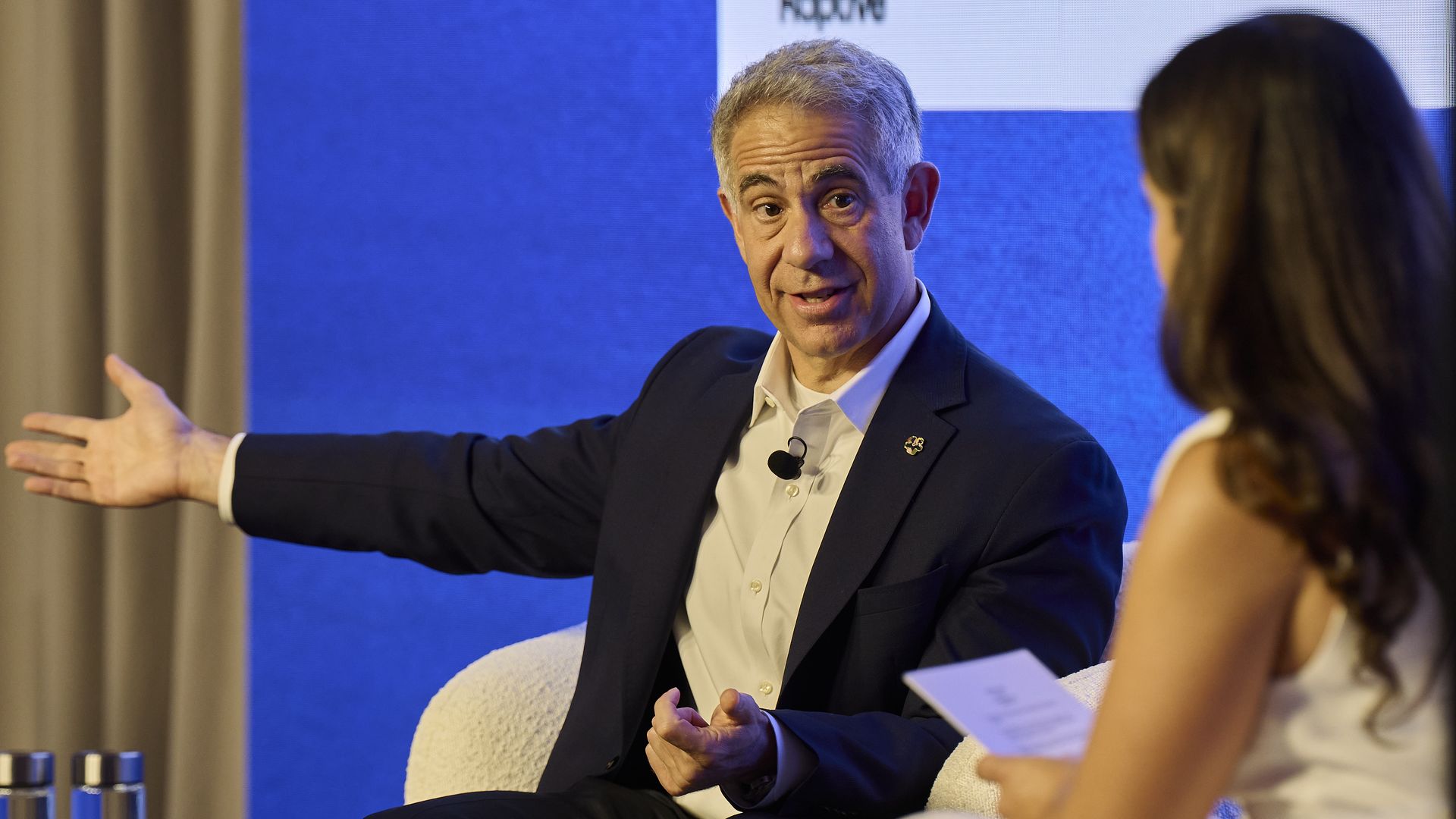 Michael Sanchez gestures while speaking with Maria Curi at the Axios AI+ Summit in New York in June 2024