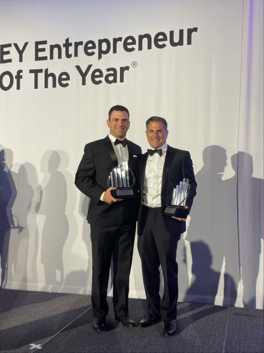 Michael and David Saoud in dinner jackets holding EY Entrepreneur Of The Year awards