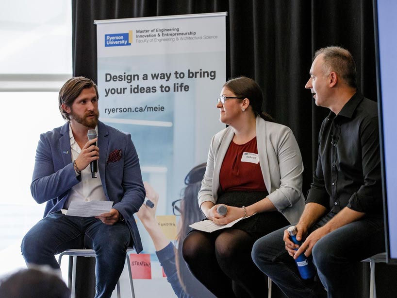 Wesley Kosiba and Aly Burtch interview Michael Serbinis, seated at right, onstage in 2019.