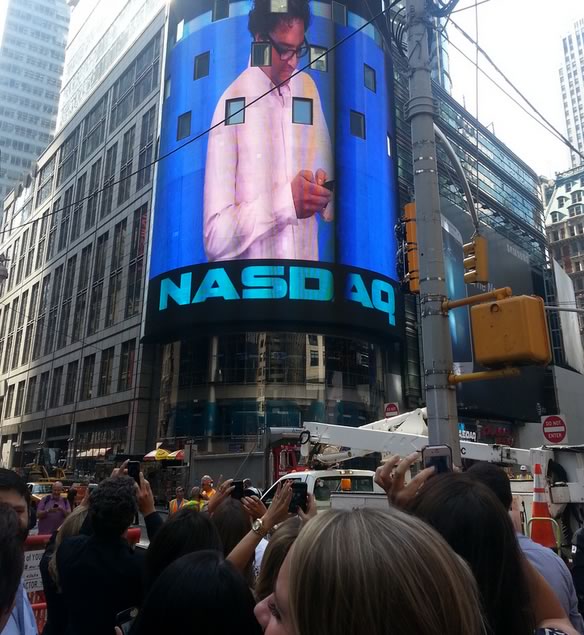StreetEasy co-founder Sebastian Delmont shown on the Nasdaq tower screen above a crowd in Times Square