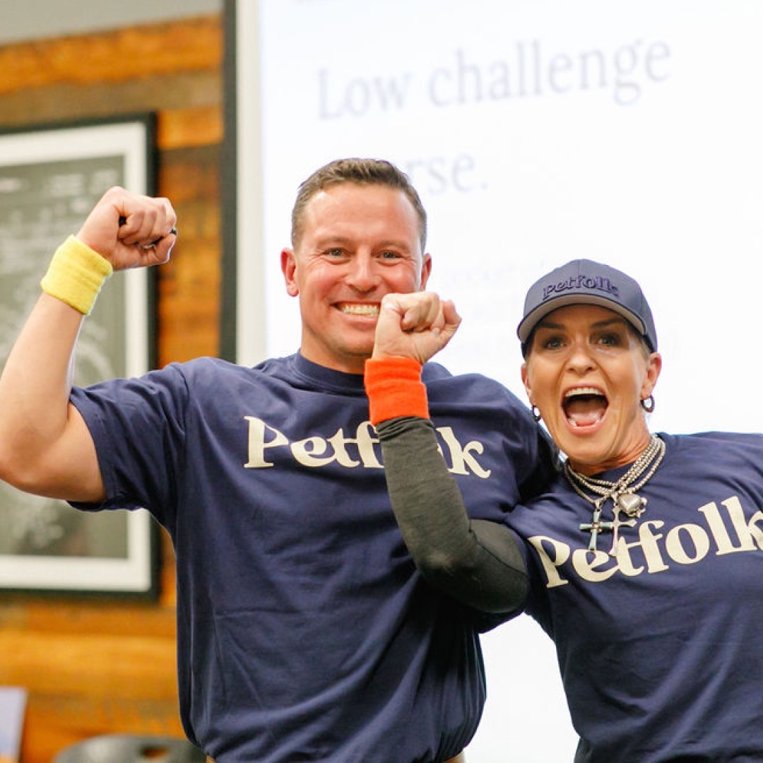 Michael and Audrey Wystrach raising their arms while wearing Petfolk shirts