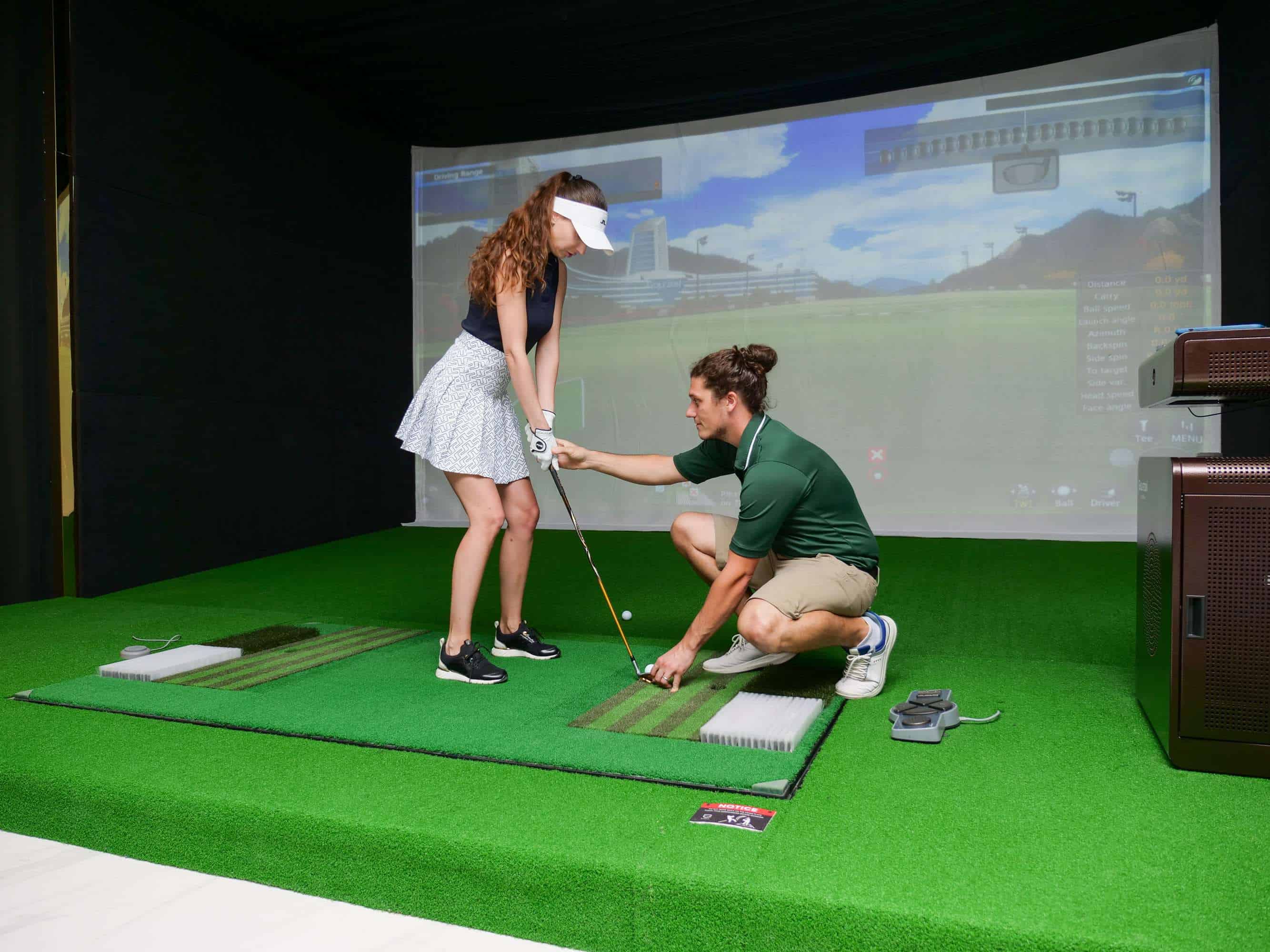 The interior of MyGolf Dubai, with indoor golf simulator bays and lounge seating.