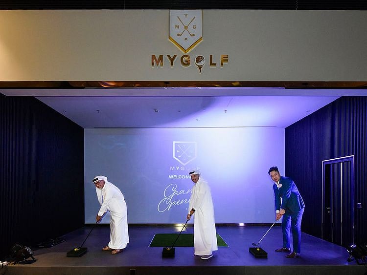 Michael Zhao, at right, takes a ceremonial golf stance alongside Saeed Hareb and Mubarak Bin Fahad at MyGolf Dubai’s opening.