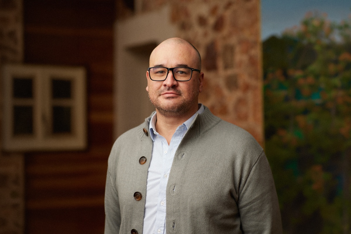 Mike Baukes wearing glasses and a grey cardigan, photographed indoors