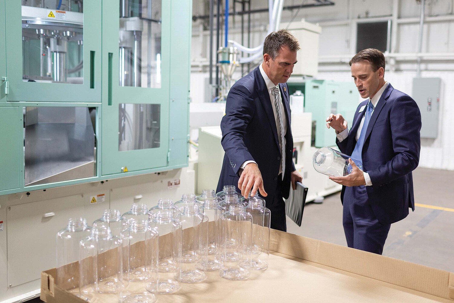 Mike Beckham, at right, showing Oklahoma Governor Kevin Stitt bottles at Simple Modern's manufacturing facility