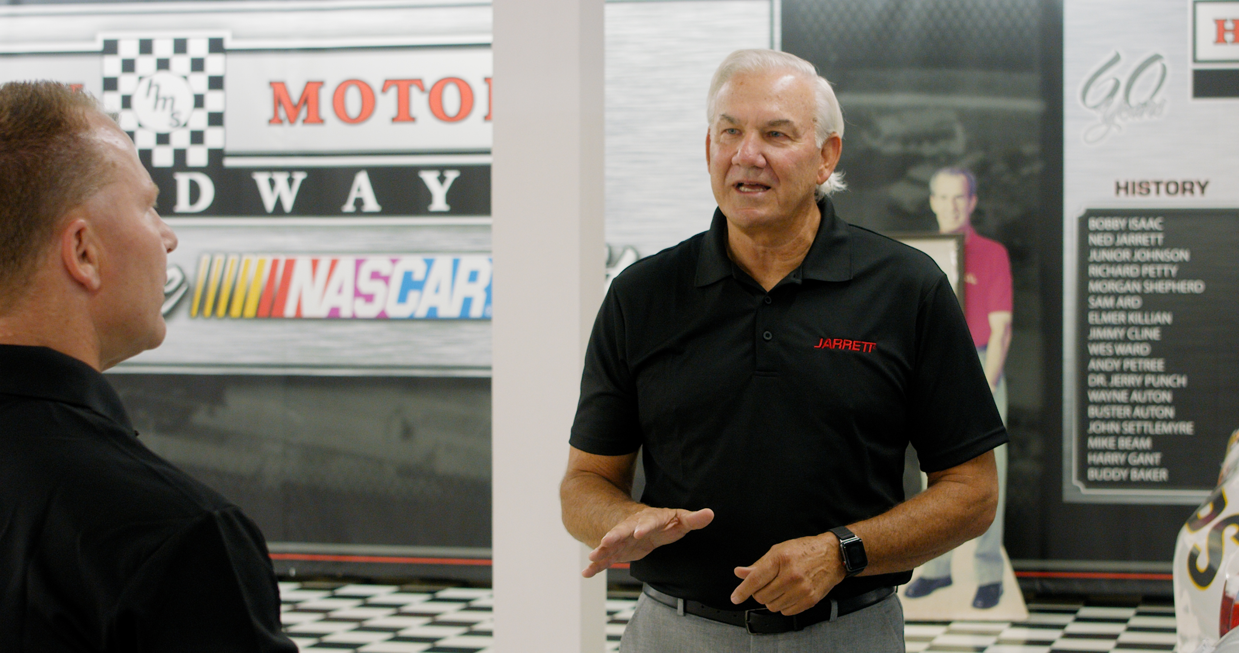 Mike Jarrett, at left, in conversation with NASCAR driver Dale Jarrett