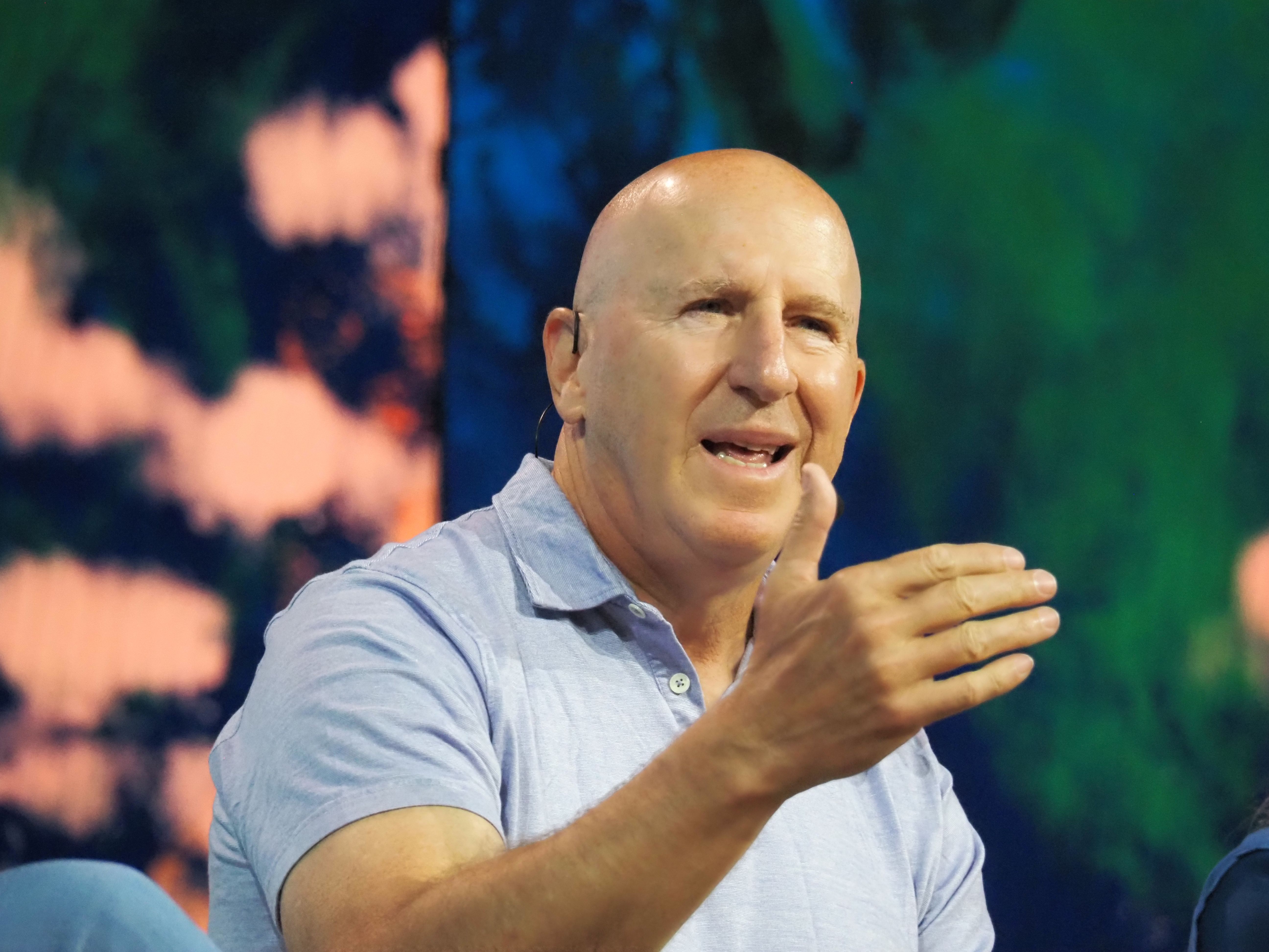 Mike Levitt speaking with a headset microphone and gesturing with his hand