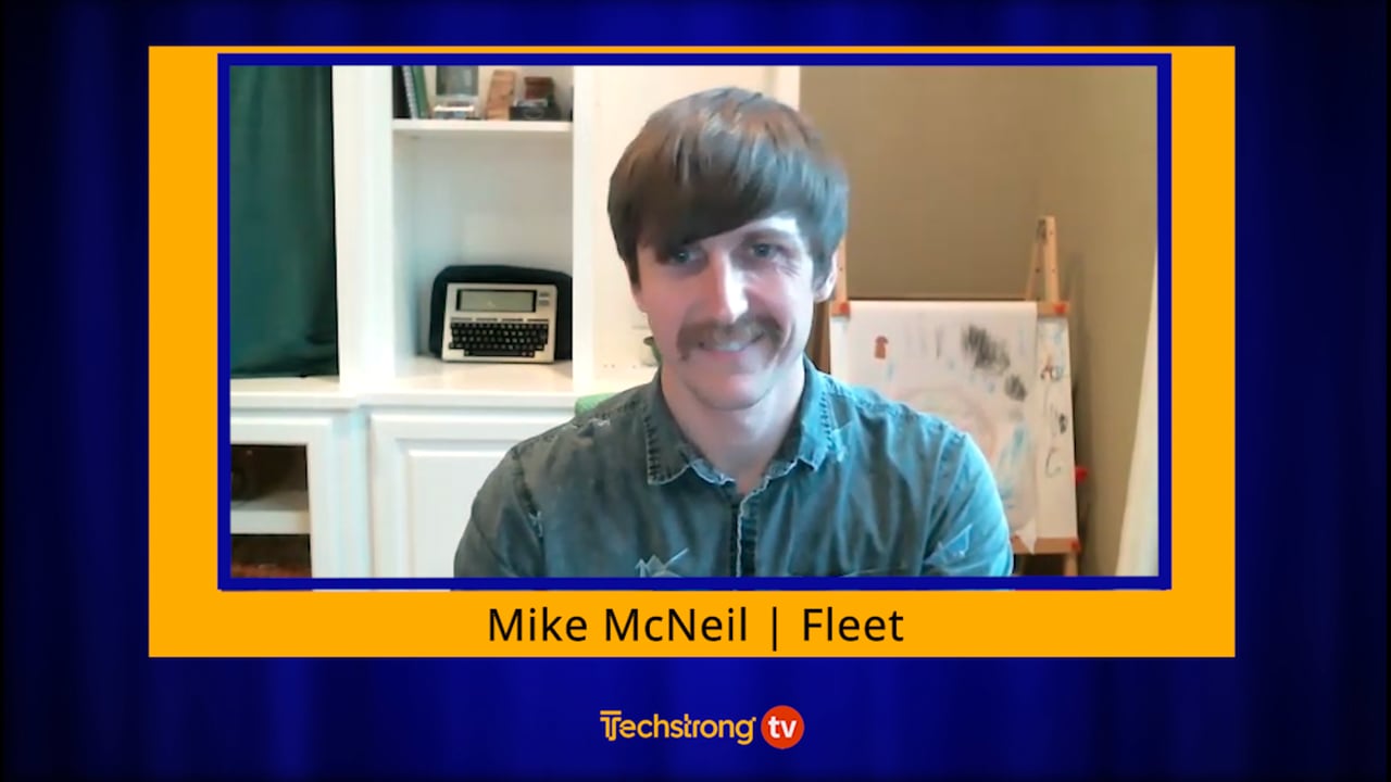 Mike McNeil speaking from his workspace during a Techstrong TV interview