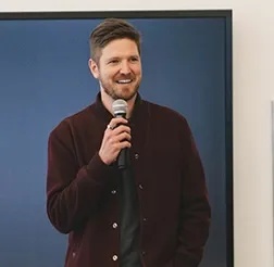 Mike Murchison holding a microphone at a DMZ founder event
