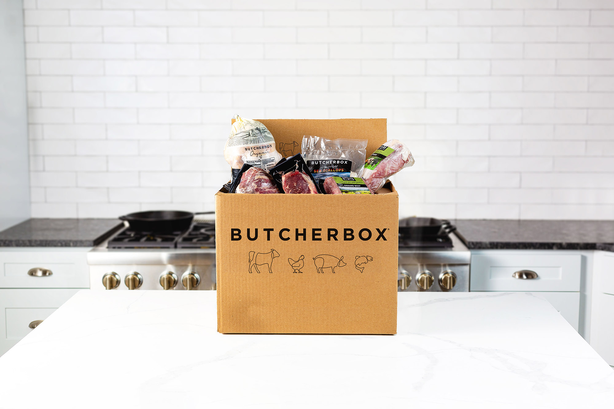 An open ButcherBox delivery box containing packaged meat and seafood