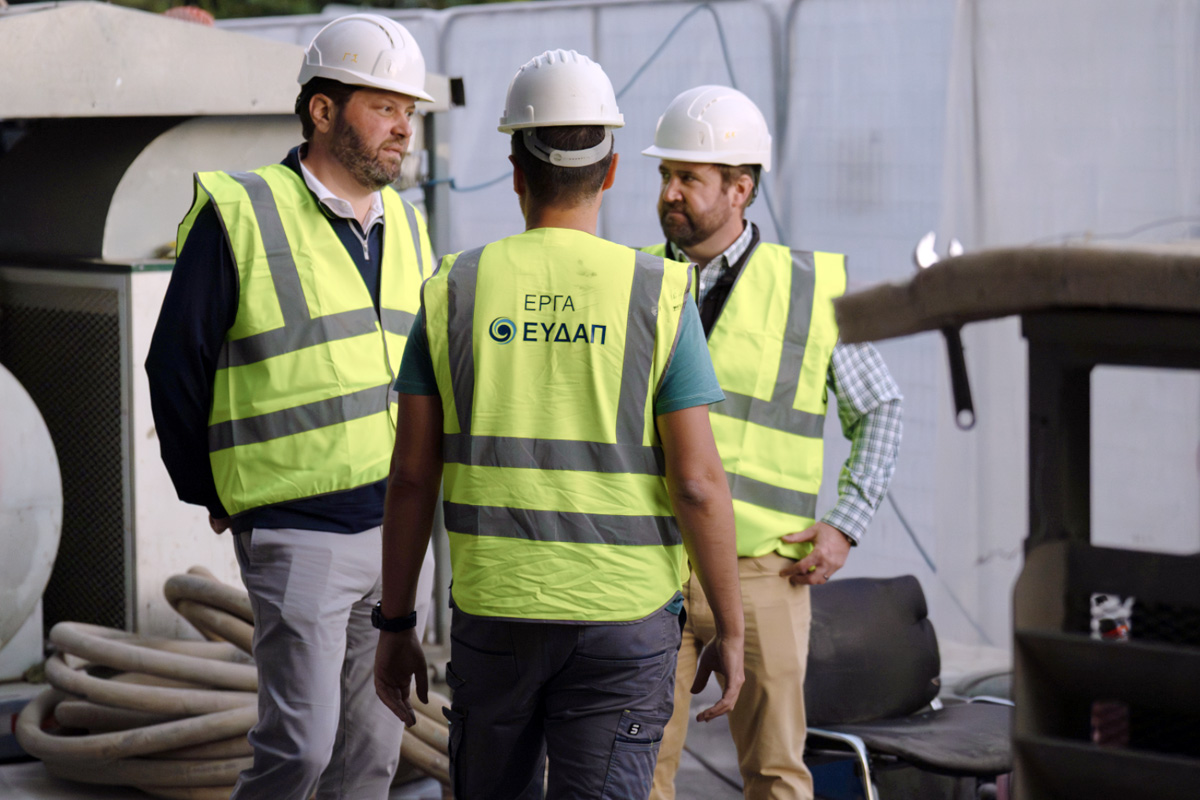 Mike Vellano, at left in a hard hat and high-visibility vest, meeting a field crew in Athens alongside Quin Breland.
