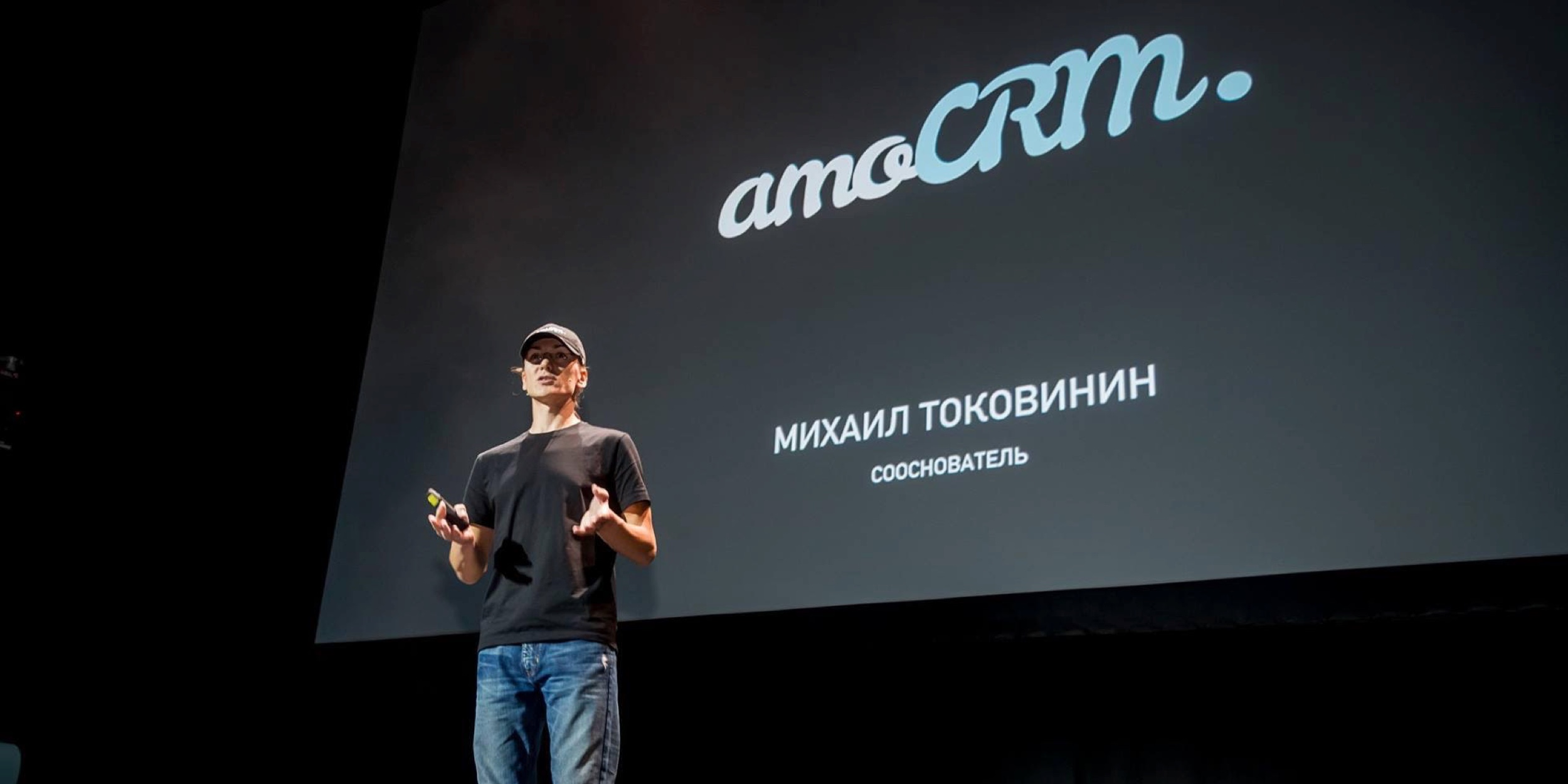 Mikhail Tokovinin speaking onstage at an amoCRM presentation