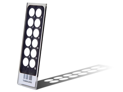 A PathogenDx glass microarray standing upright and casting a grid-like shadow
