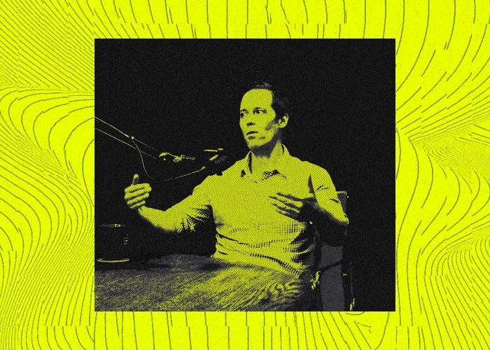 Miles Lasater speaking into a microphone during his Forward Obsessed interview, in the show's yellow graphic treatment