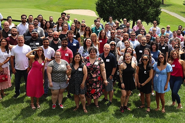A large group of Millennium Systems International team members outdoors