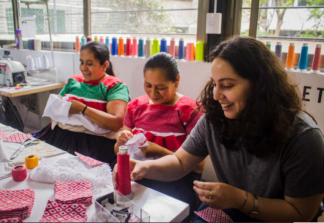 Three women working with colorful embroidery thread at Someone Somewhere