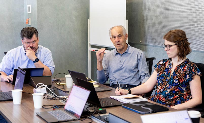 CareFlowIQ team members working around a conference table with laptops