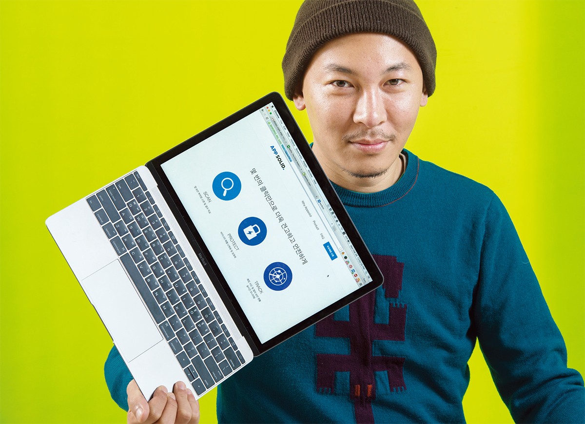 Min Pyo Hong holding a laptop with the AppSolid scan, protect and track interface