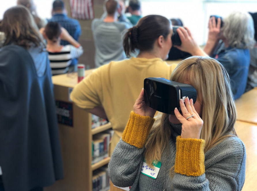 Teachers exploring virtual reality headsets during a professional development session