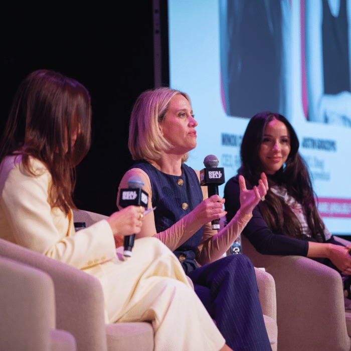 Minou Clark seated onstage with fellow panelists at the 2026 Real Talk Summit
