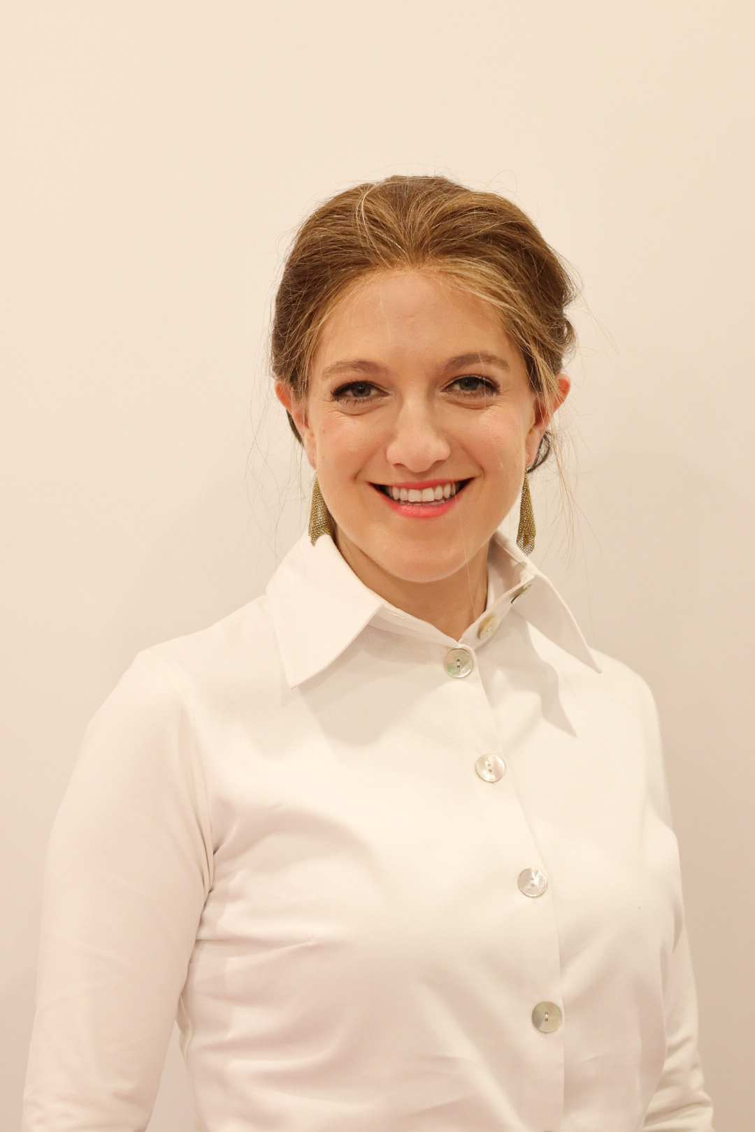 Miriam Manela Frankel smiling in a white blouse