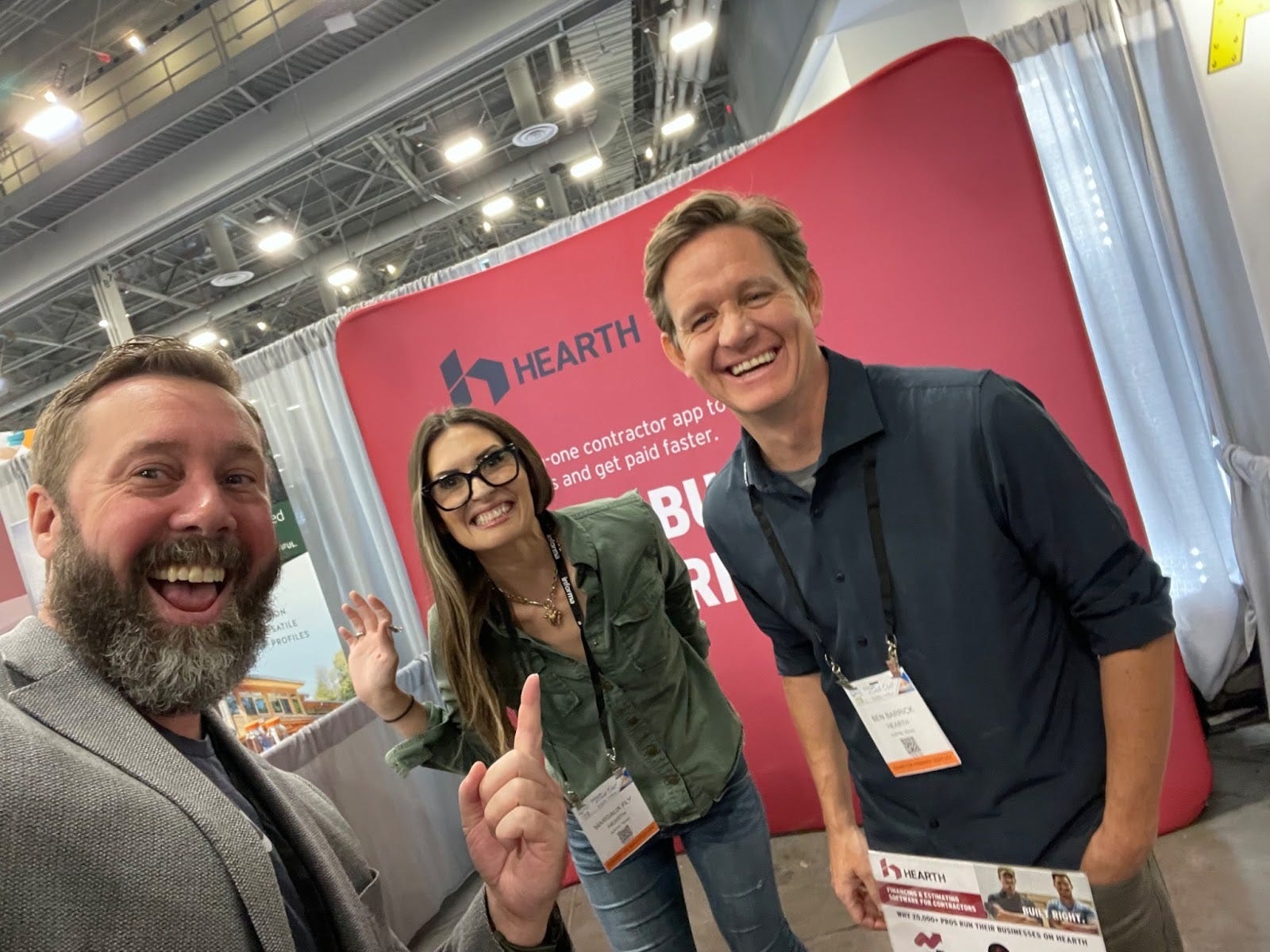 Three members of the Hearth community smiling at a home-services trade show booth