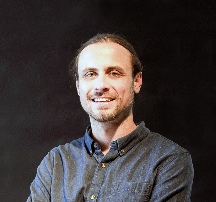 Mission Bay Media founder Lucas Rohm smiling in a blue shirt