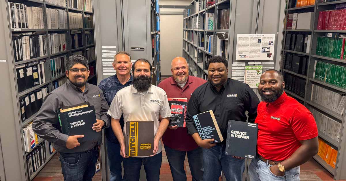 Mitchell 1 regional sales team photographed among shelves of repair manuals
