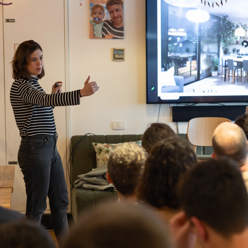 Mixtiles colleagues gather for a presentation in a room decorated with photographs