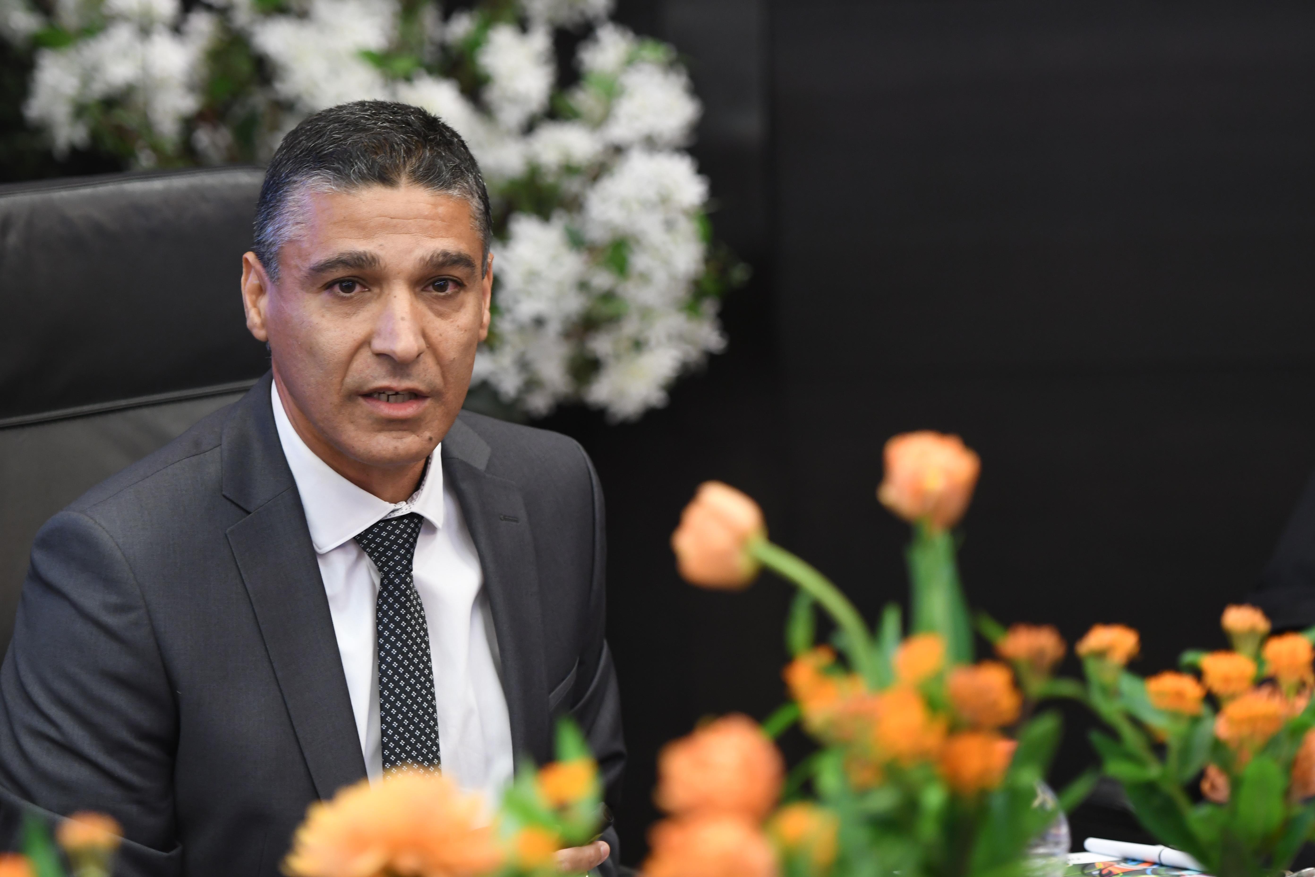 Mizrahi-Tefahot CEO Moshe Lari seated at a table with orange flowers in the foreground
