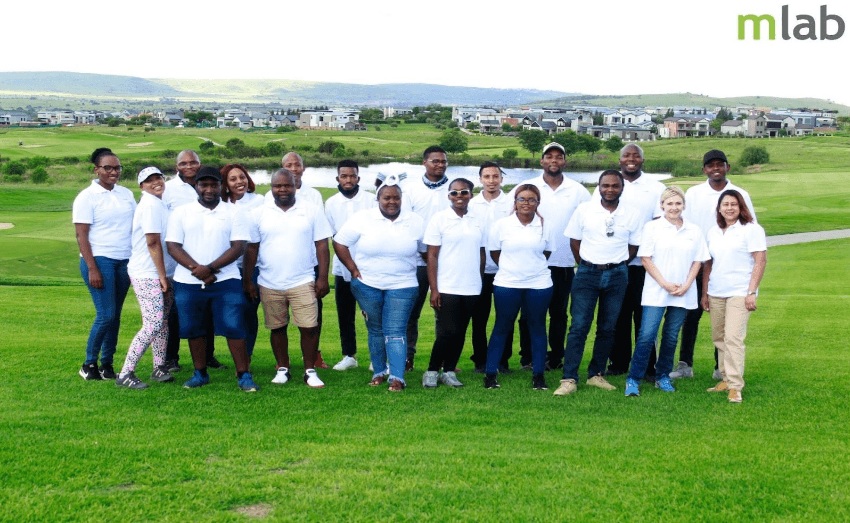 mLab staff gathered outdoors on a lawn