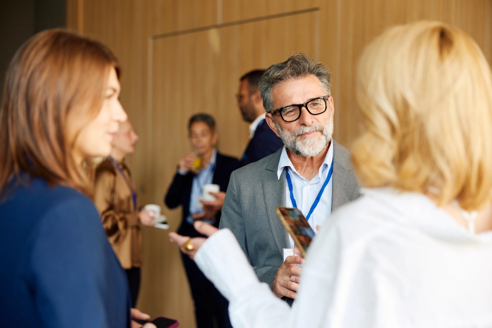 People talking together at a gathering pictured on Modus Create’s About page