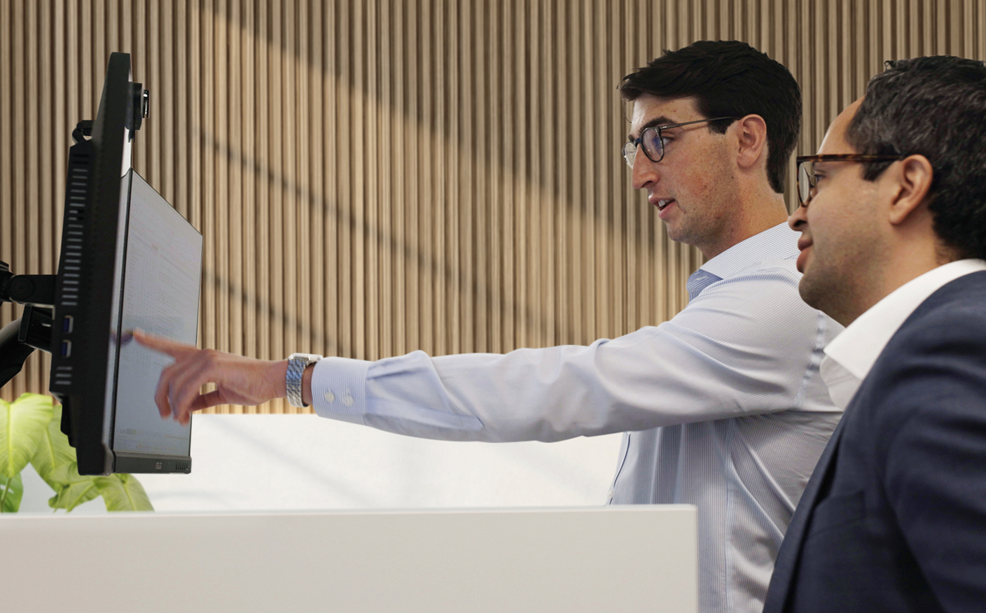 Two Moelis colleagues reviewing a computer screen together