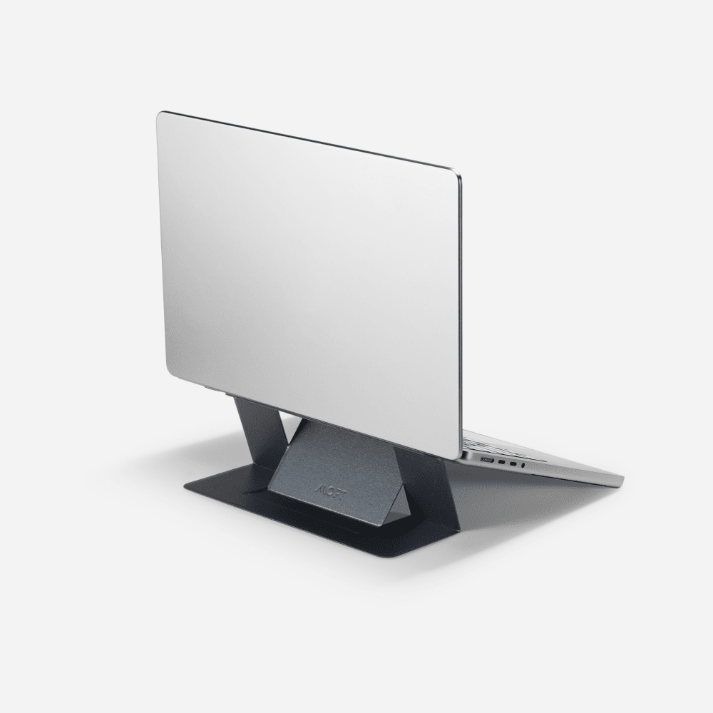 A MacBook raised on MOFT's thin black adhesive invisible laptop stand