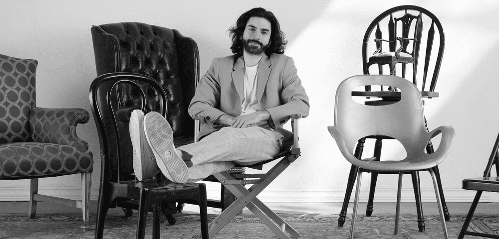Mo Said seated in a director’s chair among an assortment of empty chairs