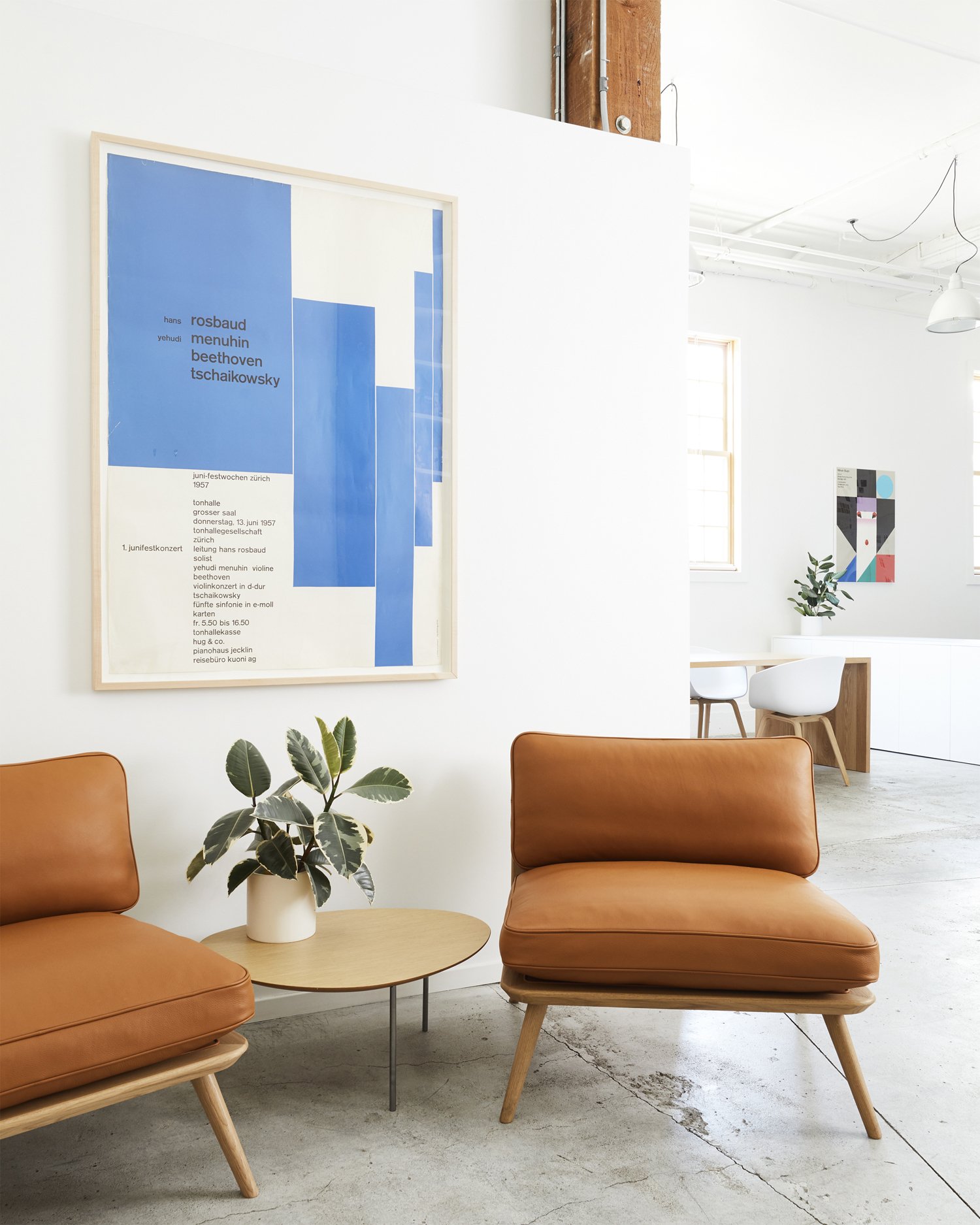 Orange lounge chairs, a blue typographic poster and timber structure in Moniker’s renovated studio