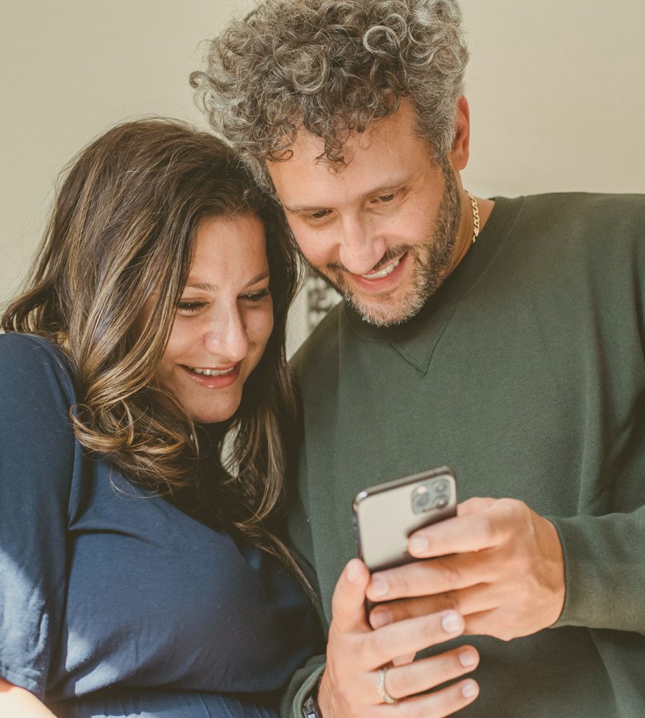 Two people looking at a smartphone in Monument’s promotional photography