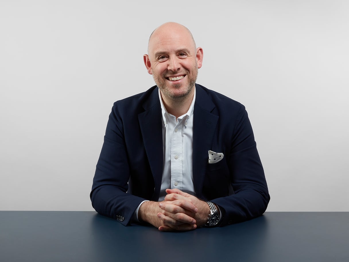 Richard Moross seated at a table in MOO’s official founder portrait