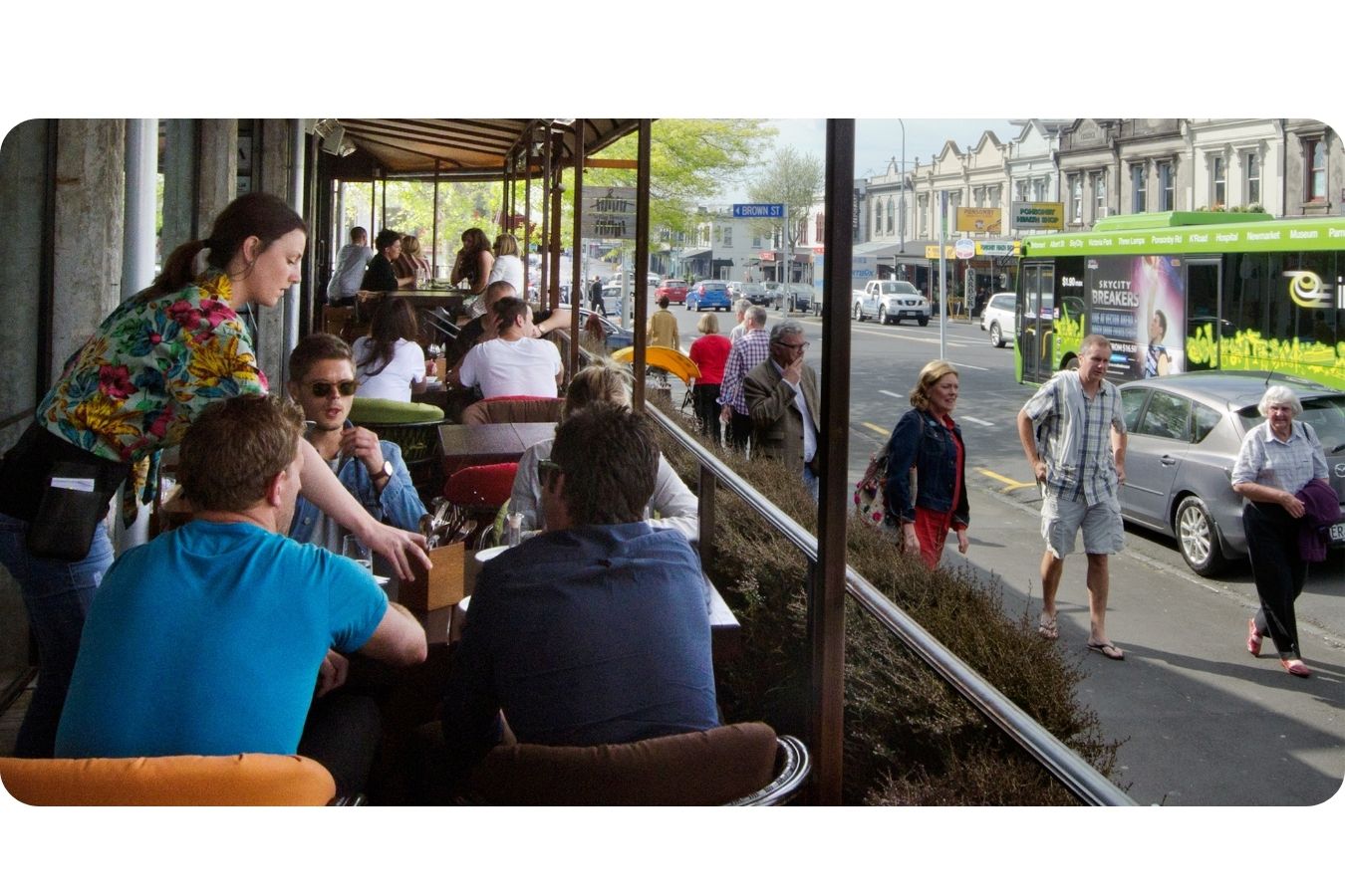 People, cars and a bus sharing a busy Auckland street